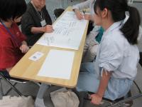 参加者と筆談で話す学生ボランティア